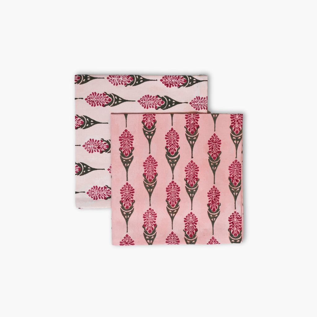 A set of two pink Bahaar cotton table napkins with hand-block printed larkspur floral patterns.