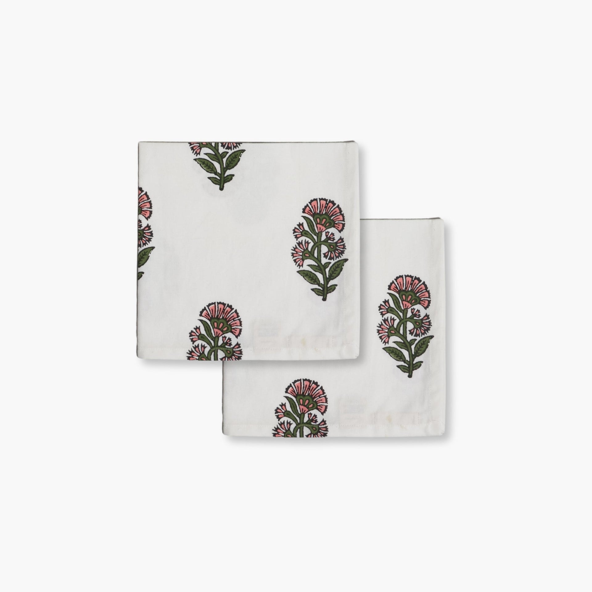 Hand-block printed floral cotton napkins in pink and green on a white base for bohemian dining decor.