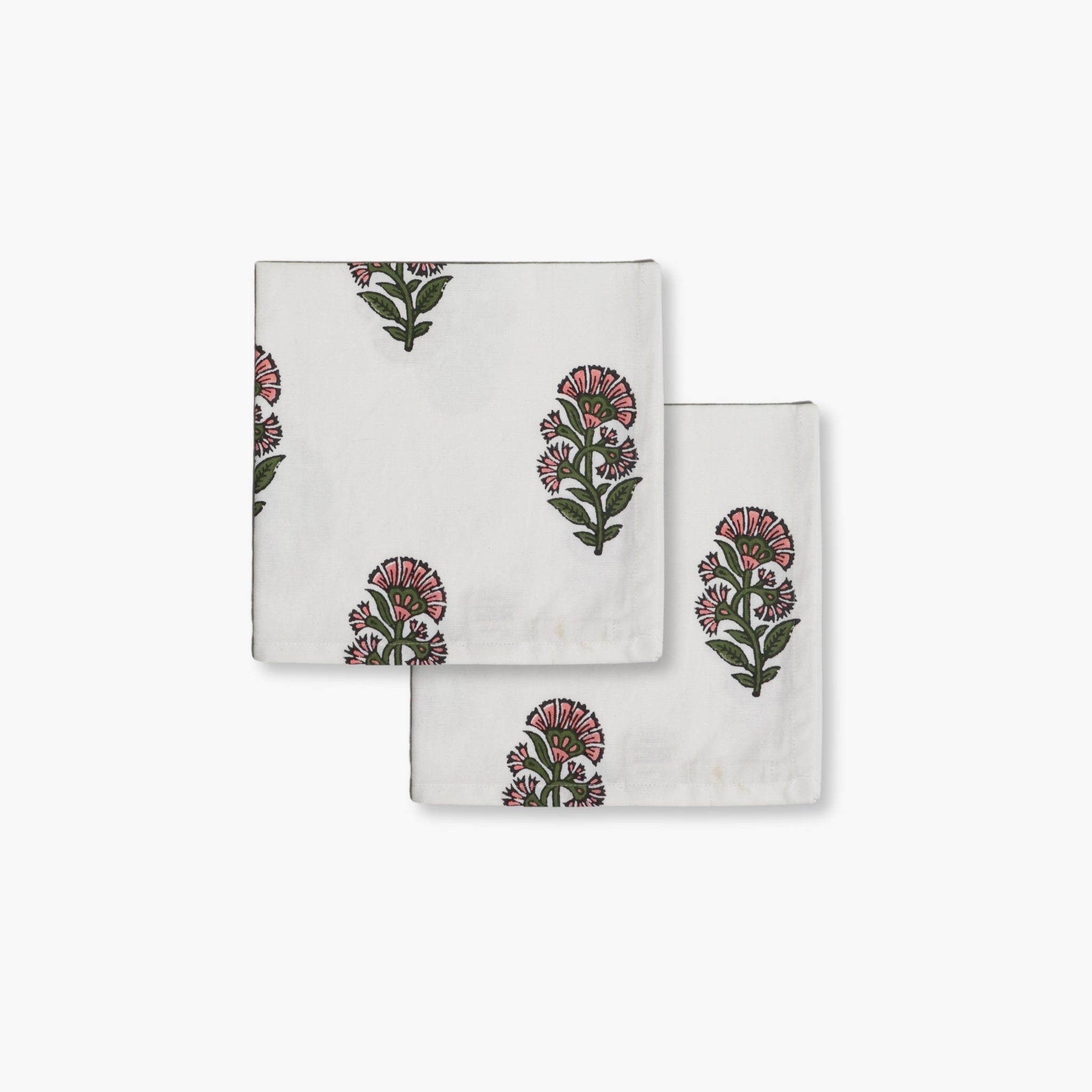 Hand-block printed floral cotton napkins in pink and green on a white base for bohemian dining decor.