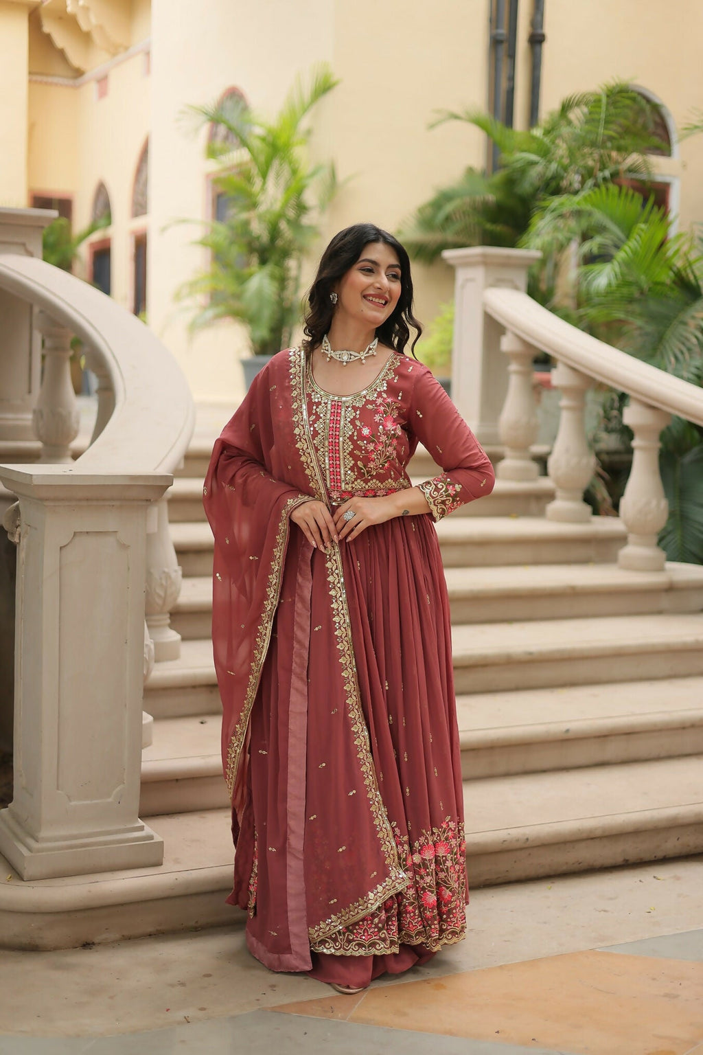 Woman wearing a coffee-brown chiffon kurta set with gold sequence embroidery and pink accents