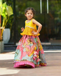 A toddler girl wearing a pink Chinon silk lehenga choli with printed details and embroidery.