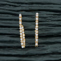 Close-up view of golden and white AD brass earrings showcasing intricate craftsmanship.