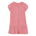 Woman wearing a strawberry-pink terry ruffle swim cover-up on a beach