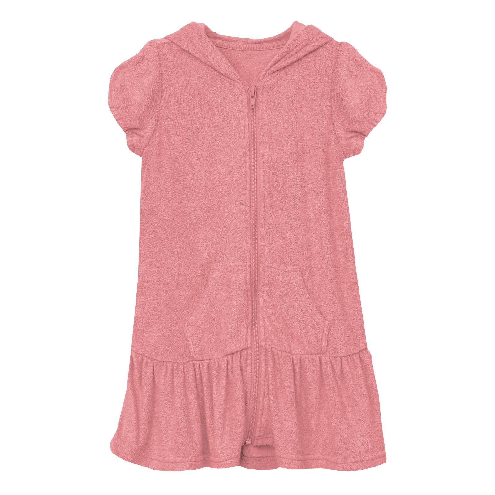 Woman wearing a strawberry-pink terry ruffle swim cover-up on a beach