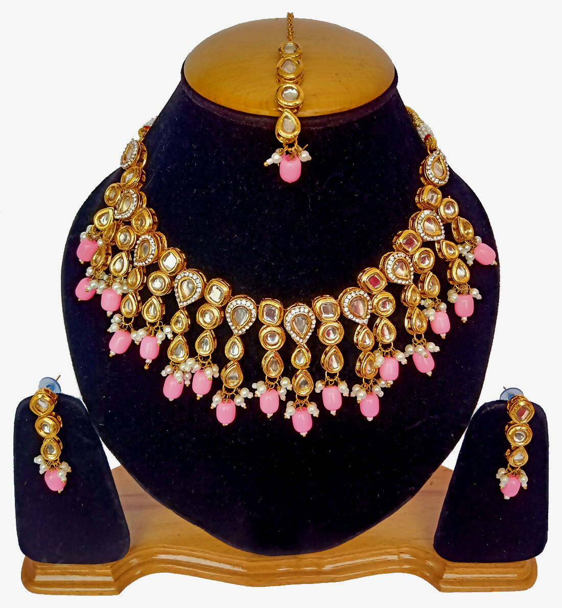 Handcrafted gold-plated Kundan necklace set with stone studs on a display mannequin