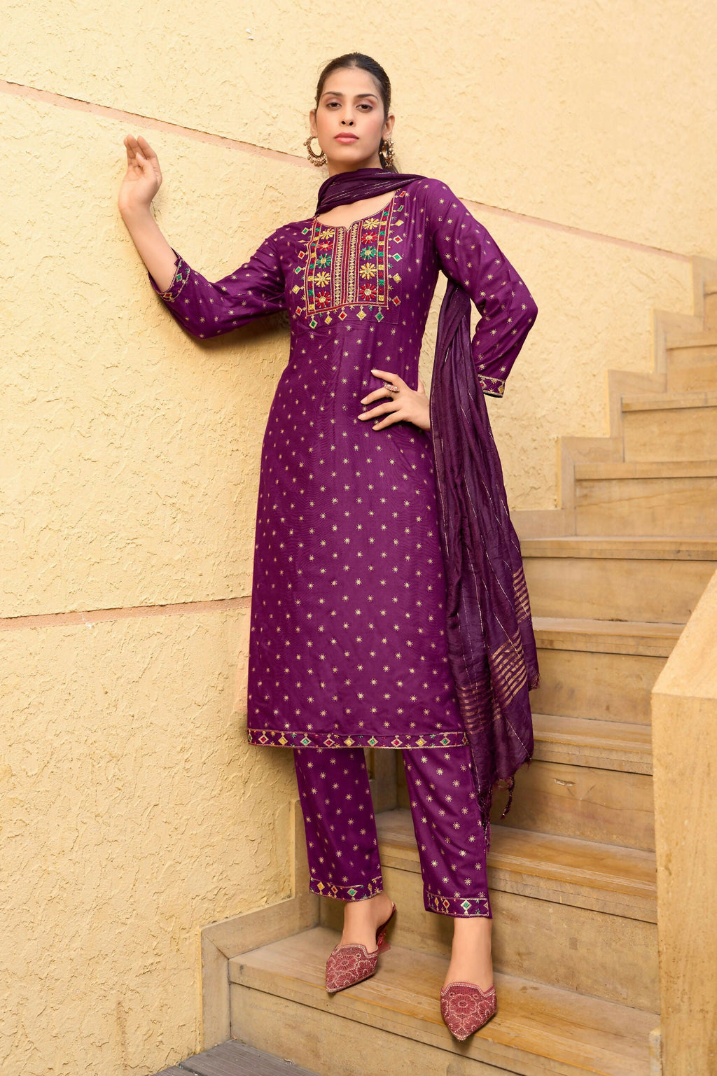 Woman wearing a wine-colored knee-length rayon kurta with foil print and embroidery detail.