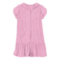 Woman wearing a bright bubblegum pink terry ruffle swim cover-up on a sunny beach day.