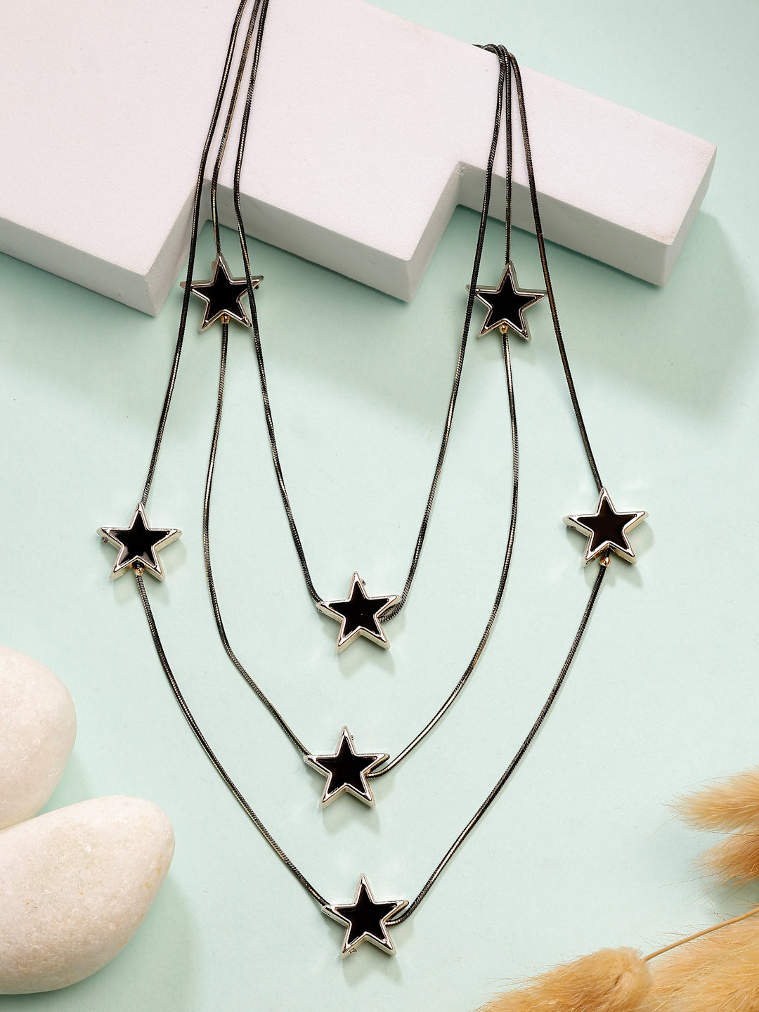 Black star-shaped layered fashion necklace with multiple pendants for a celestial look