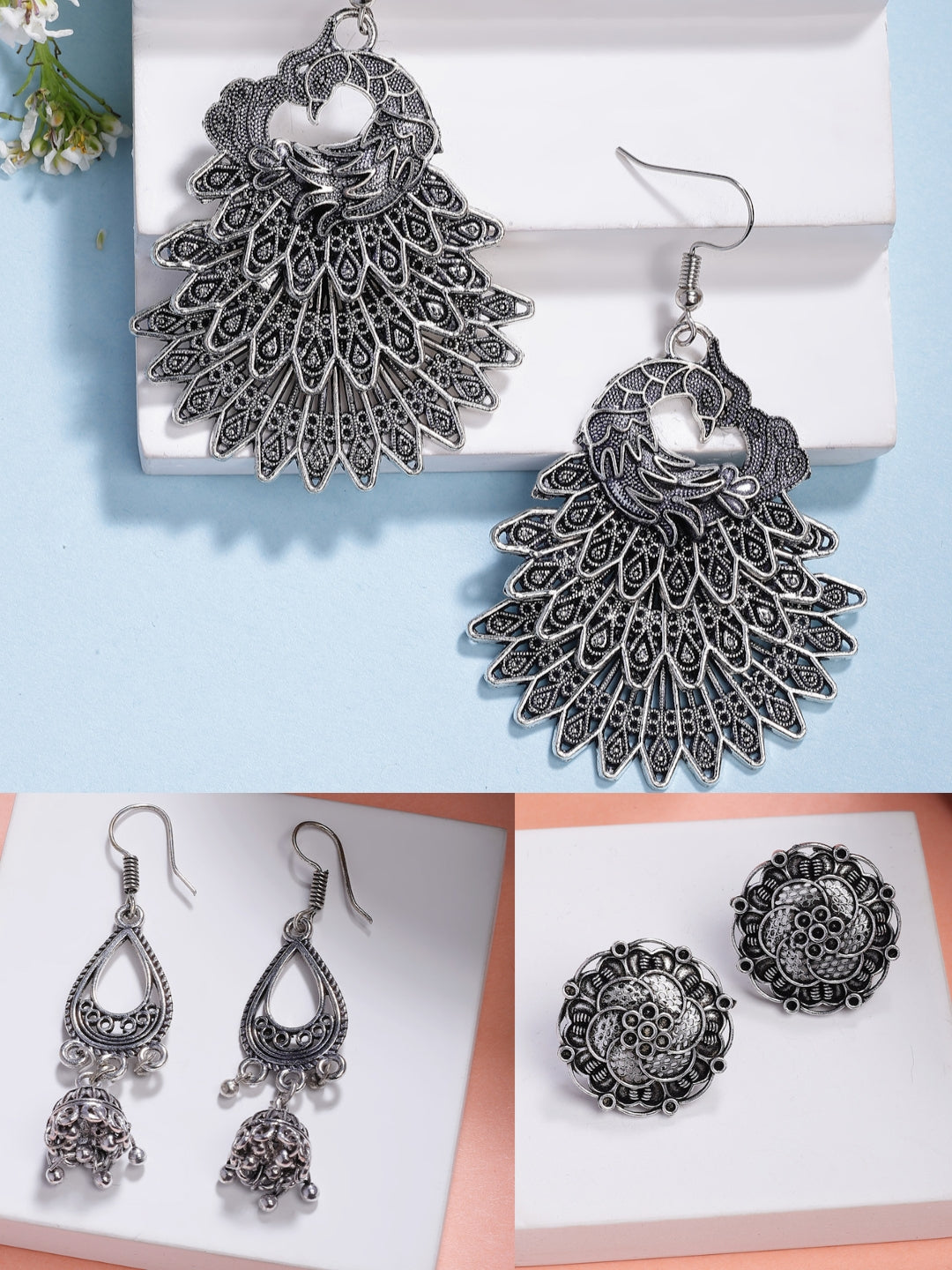 Set of three silver-plated oxidized traditional earrings including jhumkas, studs, and drop styles.