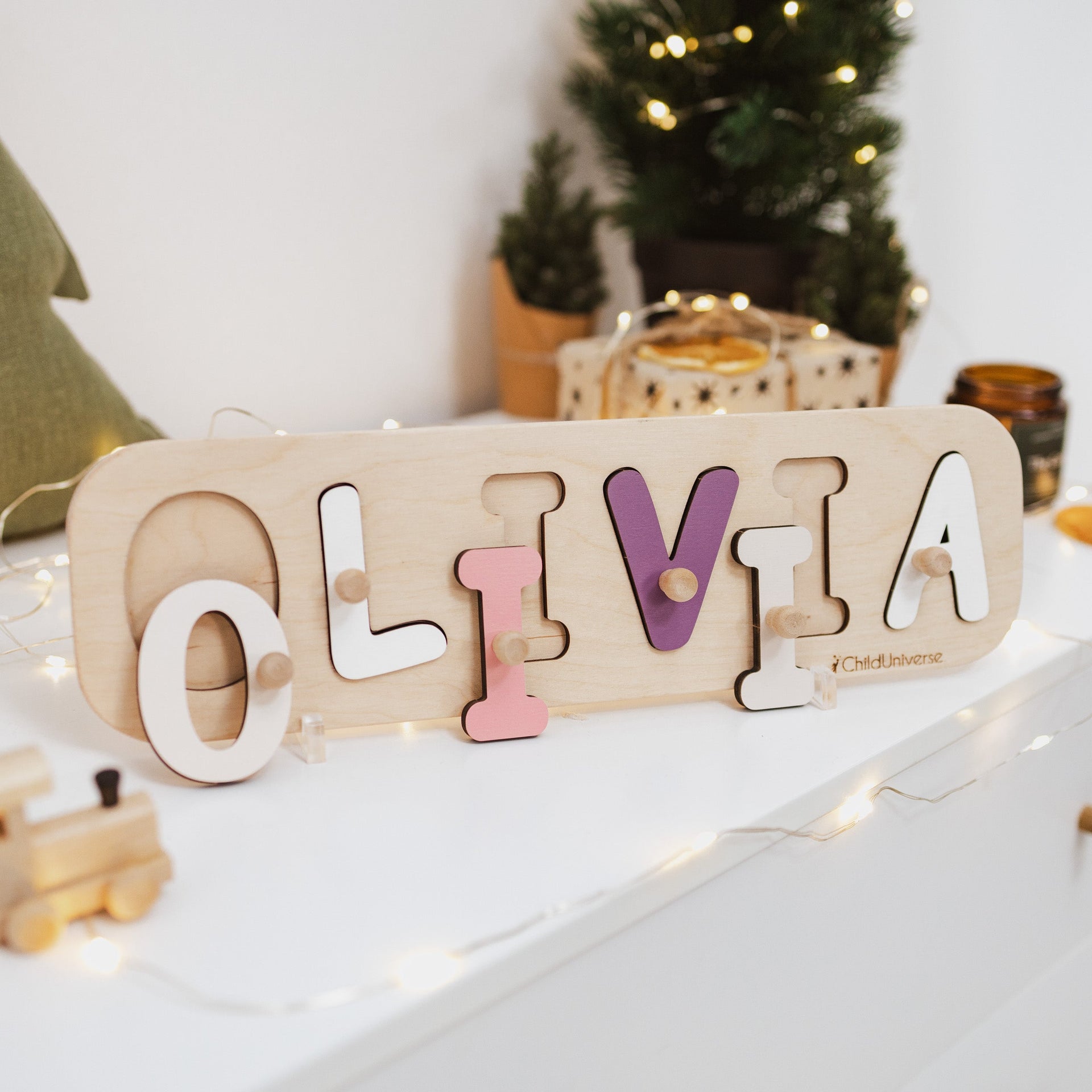Custom wooden name puzzle in natural birch with pastel letters on a minimalist nursery shelf