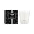 NEST New York Indian Jasmine scented candle in a white and sage green glass vessel with floral patterns.