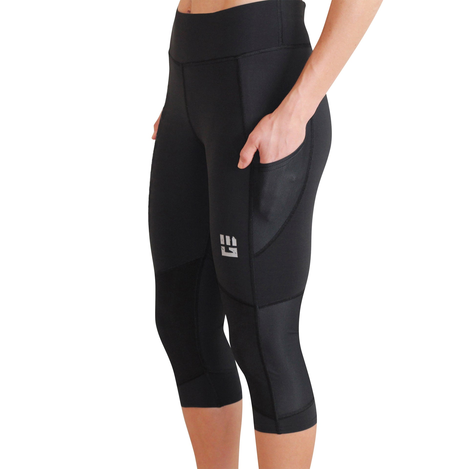 Woman wearing black compression capri leggings with side pockets designed for obstacle course racing