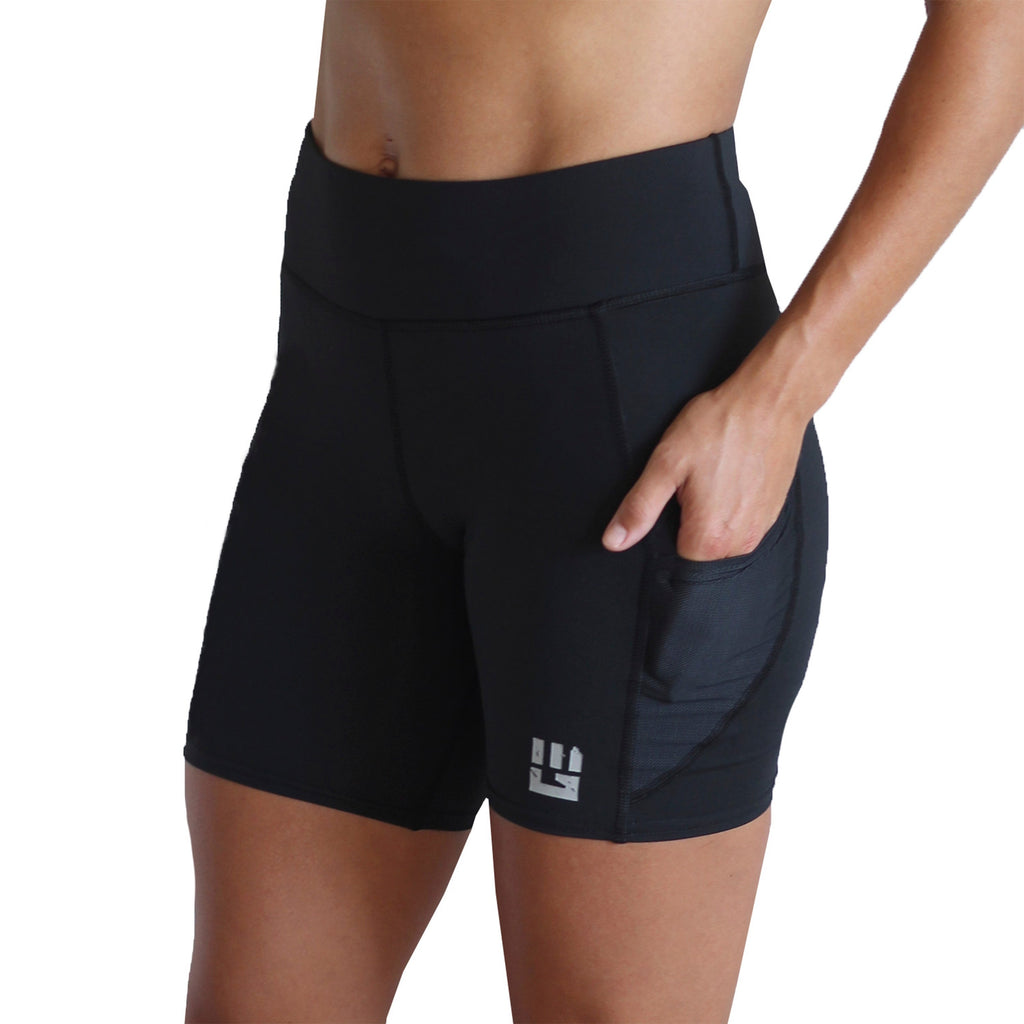 Model wearing black women's 6-inch Flex-Fit compression shorts with side pockets during an obstacle race training run.