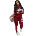 A woman wearing a matching two-piece tracksuit set including a long-sleeve hooded top and fitted joggers.