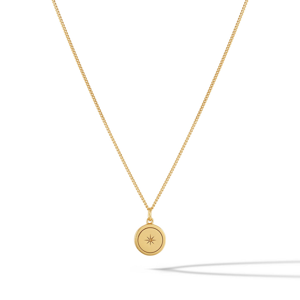 Close up of the North Star Necklace in 14k gold plated sterling silver on a minimalist background