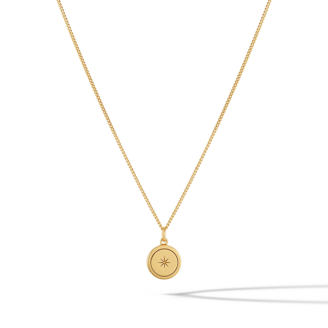 Close up of the North Star Necklace in 14k gold plated sterling silver on a minimalist background
