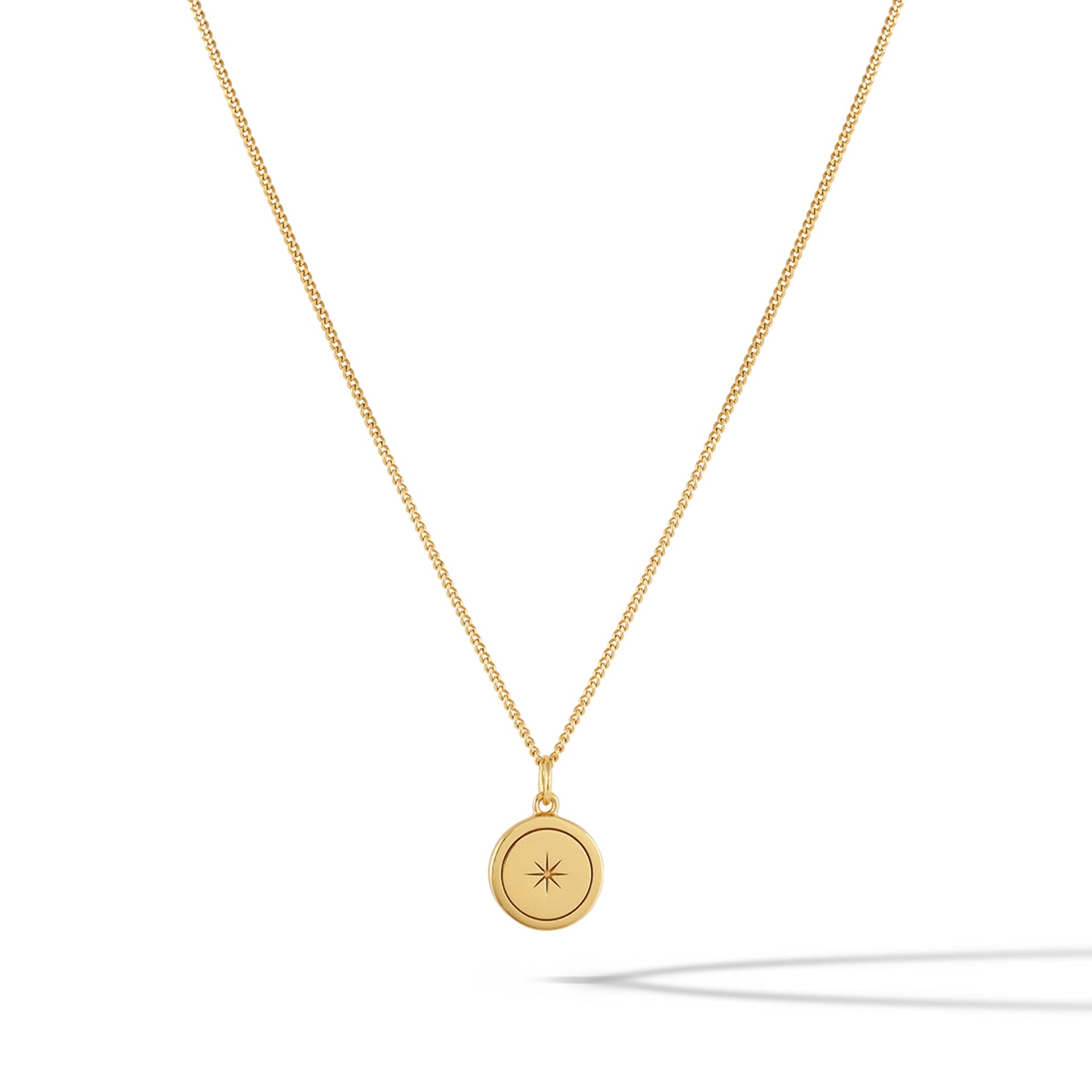 Close up of the North Star Necklace in 14k gold plated sterling silver on a minimalist background