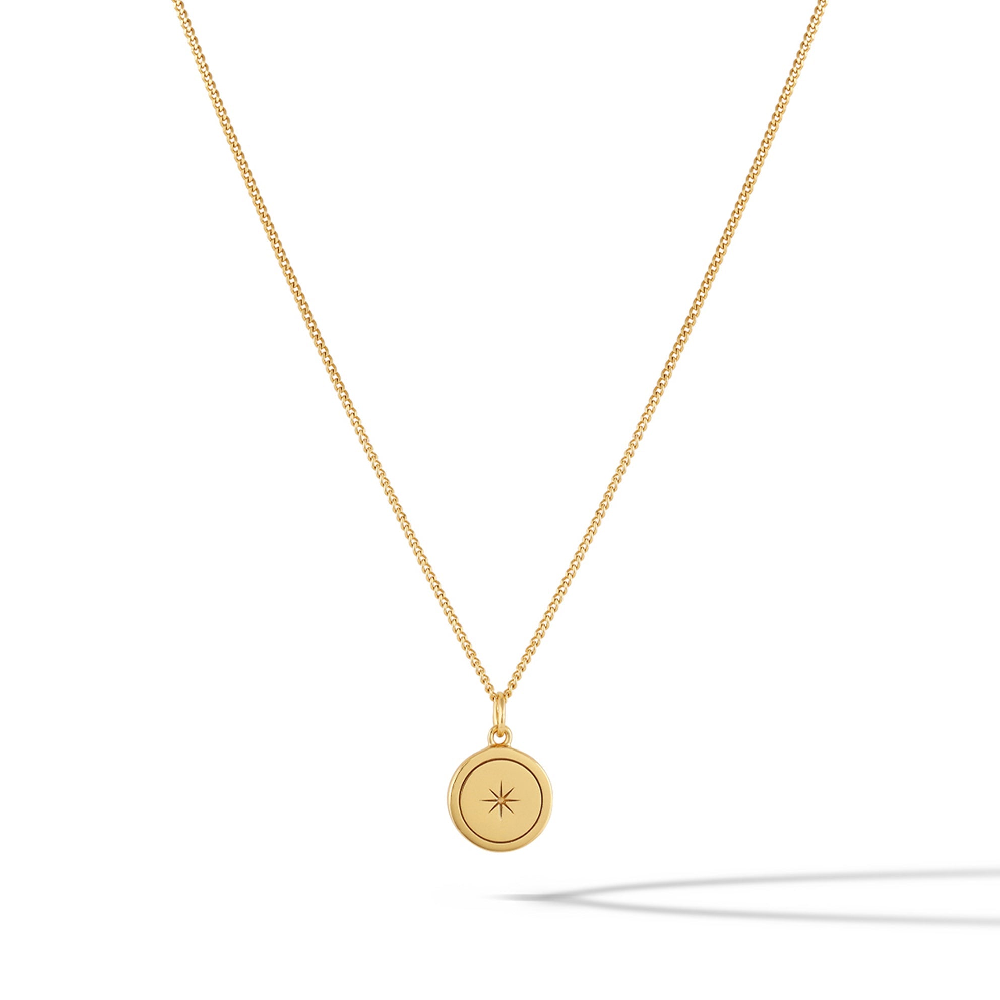 Close up of the North Star Necklace in 14k gold plated sterling silver on a minimalist background