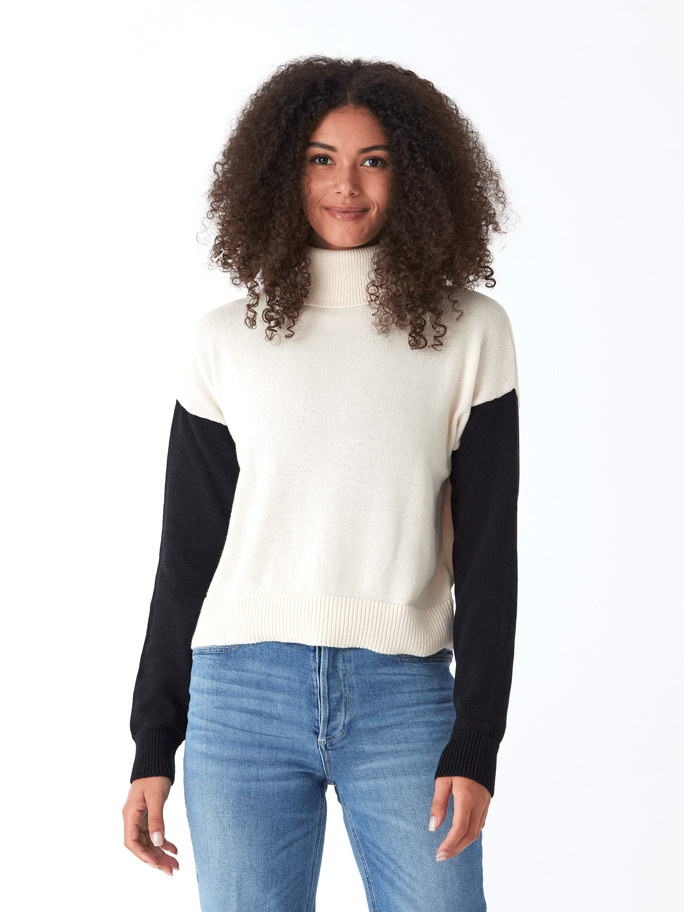 A stylish off-white and black colorblock turtleneck sweater featuring a soft knit texture.