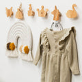 Eco-friendly wall hangers mounted in a nursery for kids clothing and accessories
