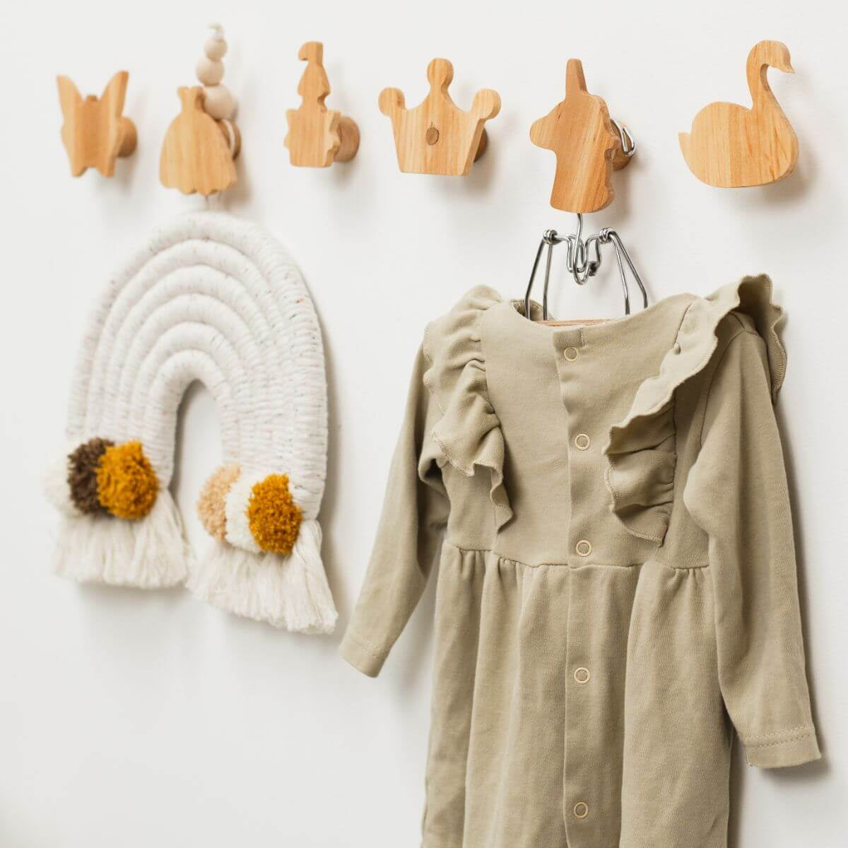 Eco-friendly wall hangers mounted in a nursery for kids clothing and accessories