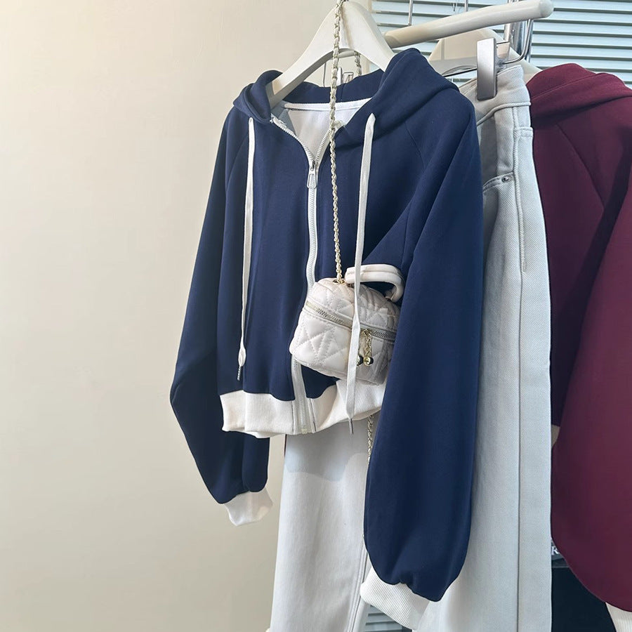 Women's navy blue and white color-blocked cropped hoodie hanging on a rack