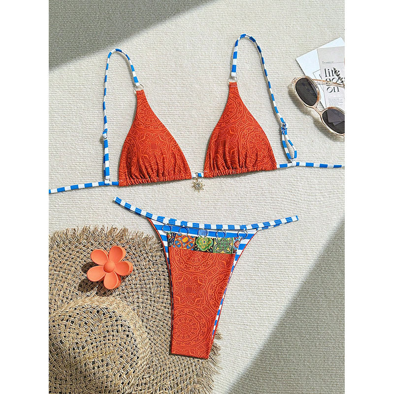 A woman posing in a geometric color block bikini with lace-up detail at a beach resort.