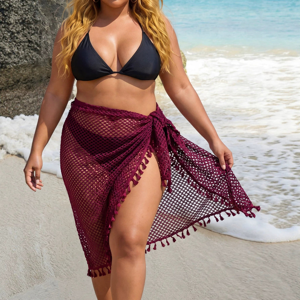 Woman wearing a sleeveless boho-style see-through beach shawl with fringe and tie details