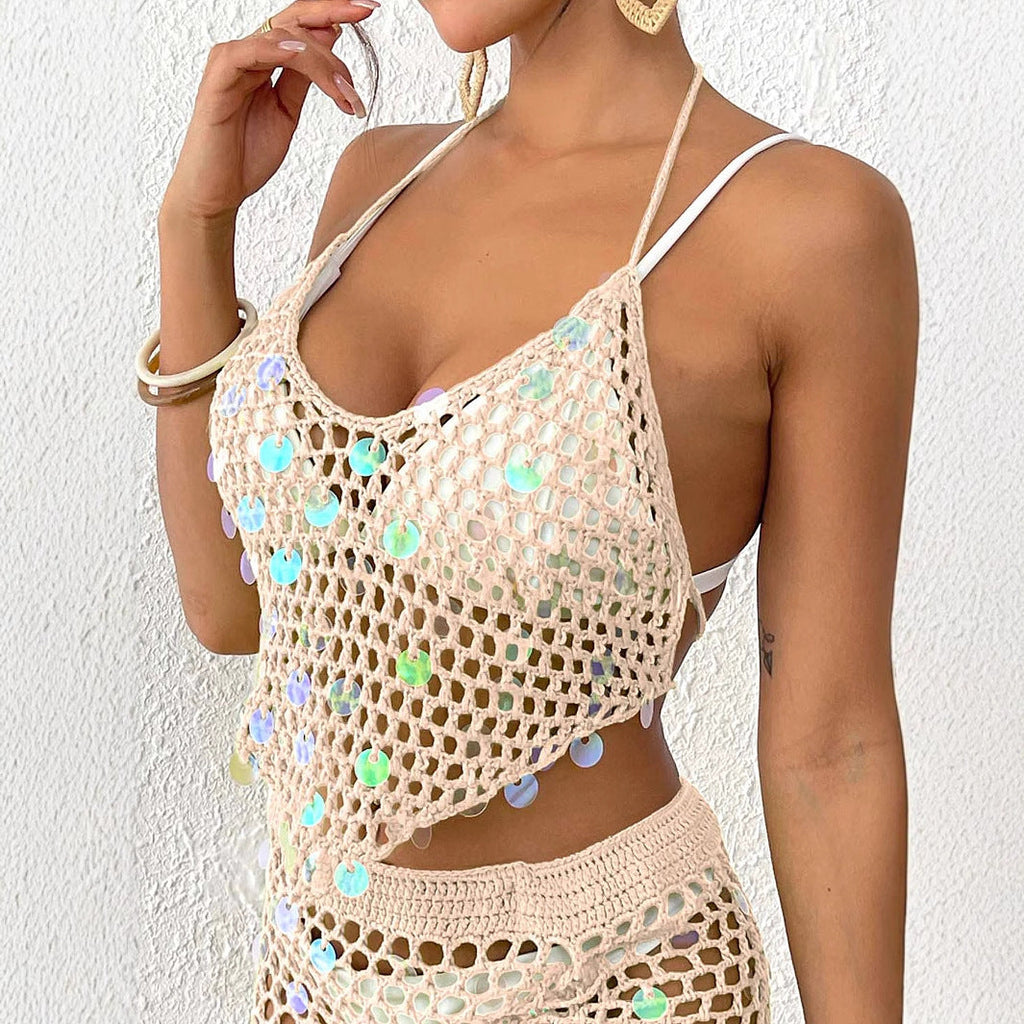 Model wearing a bohemian hand-crocheted bikini top with sequin stitching and asymmetric hemline for a beach vacation.