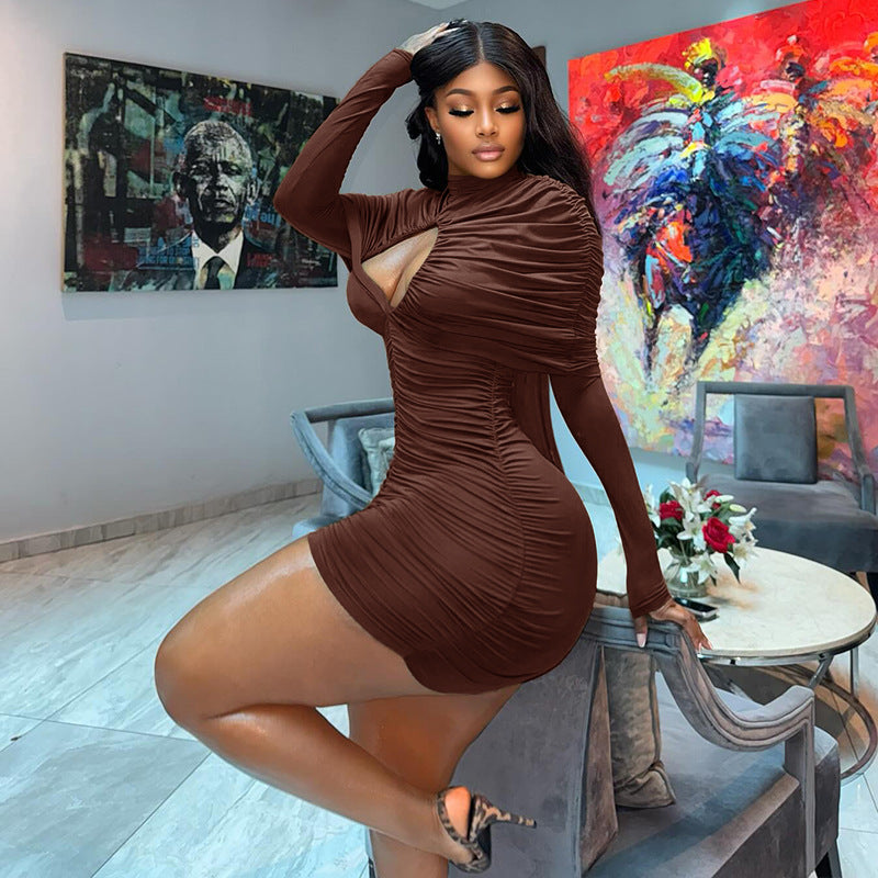 A stylish model wearing a long sleeve black turtleneck bodycon mini dress with cutout and ruched details.