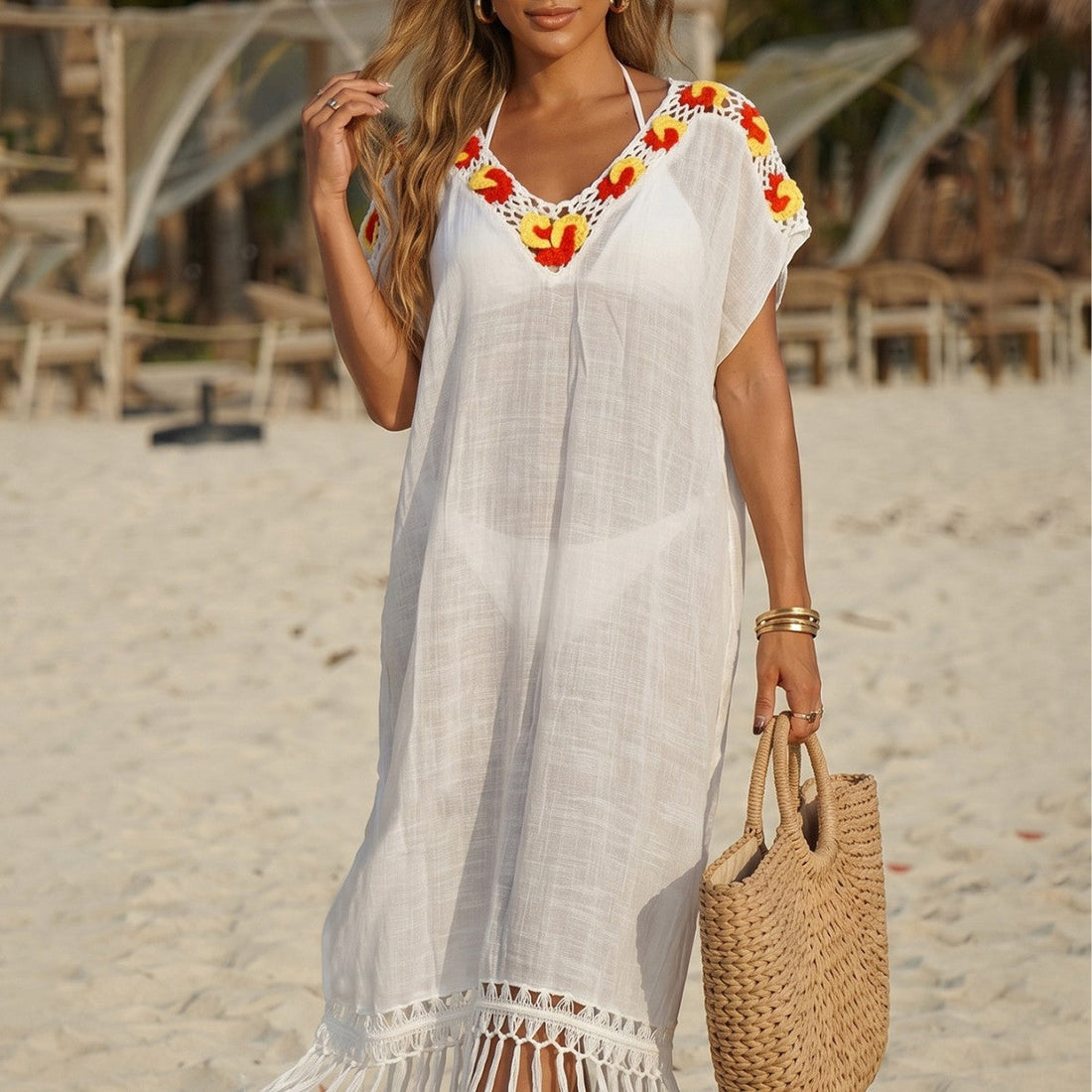 Model wearing a boho-style crochet maxi beach dress with long fringe details and short sleeves.