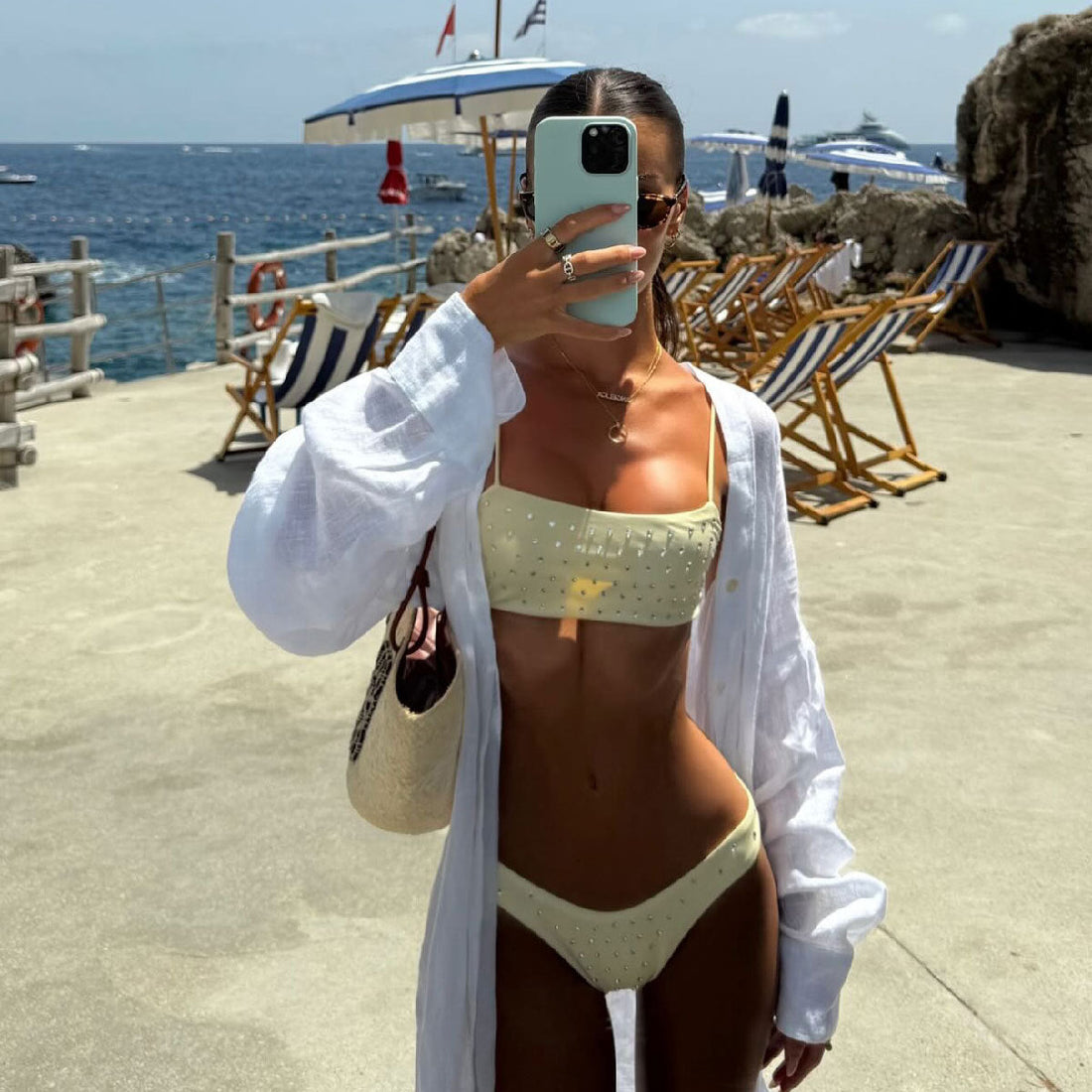Model wearing a solid color rhinestone embellished strapless tube top bikini set for summer