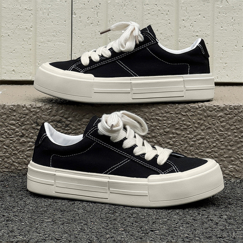 Side view of black and grey canvas platform sneakers with thick white rubber soles.