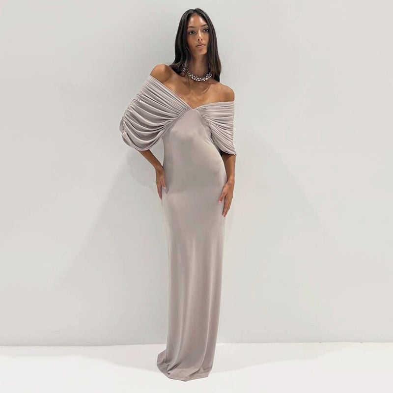 Close-up of a minimalist slim-fit maxi dress in taupe with ruched detailing and backless design
