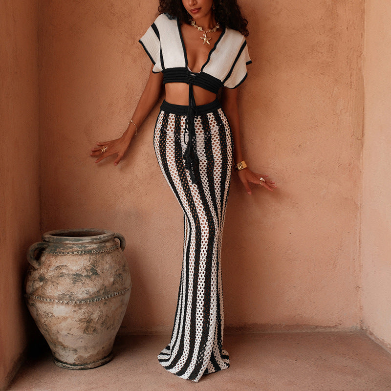 Woman wearing a black and white striped knitted lace-up two-piece cover up set on the beach