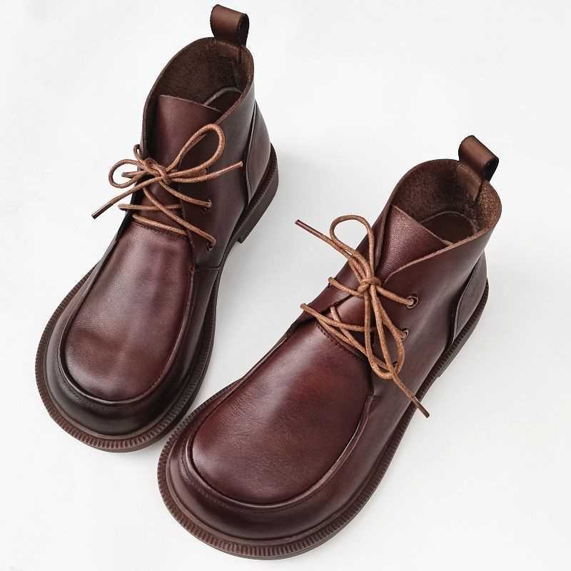 A pair of brown genuine leather ankle boots with a chunky, wide toe box and lace-up closure displayed on a white background.
