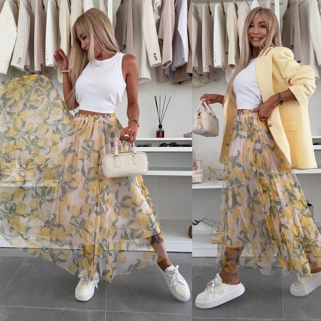 Woman wearing a flowy long mesh skirt with a vibrant yellow lemon print pattern