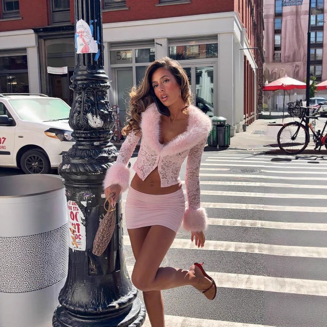 Women modeling a Bella Mia two-piece sexy lace plush long sleeve top and ruched mini skirt set in both pink and black.