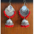 Traditional silver oxidized jhumka earrings featuring bright red pearls and mirror accents.