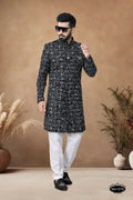 Men's black velvet indo-western kurta with intricate white and blue embroidery.