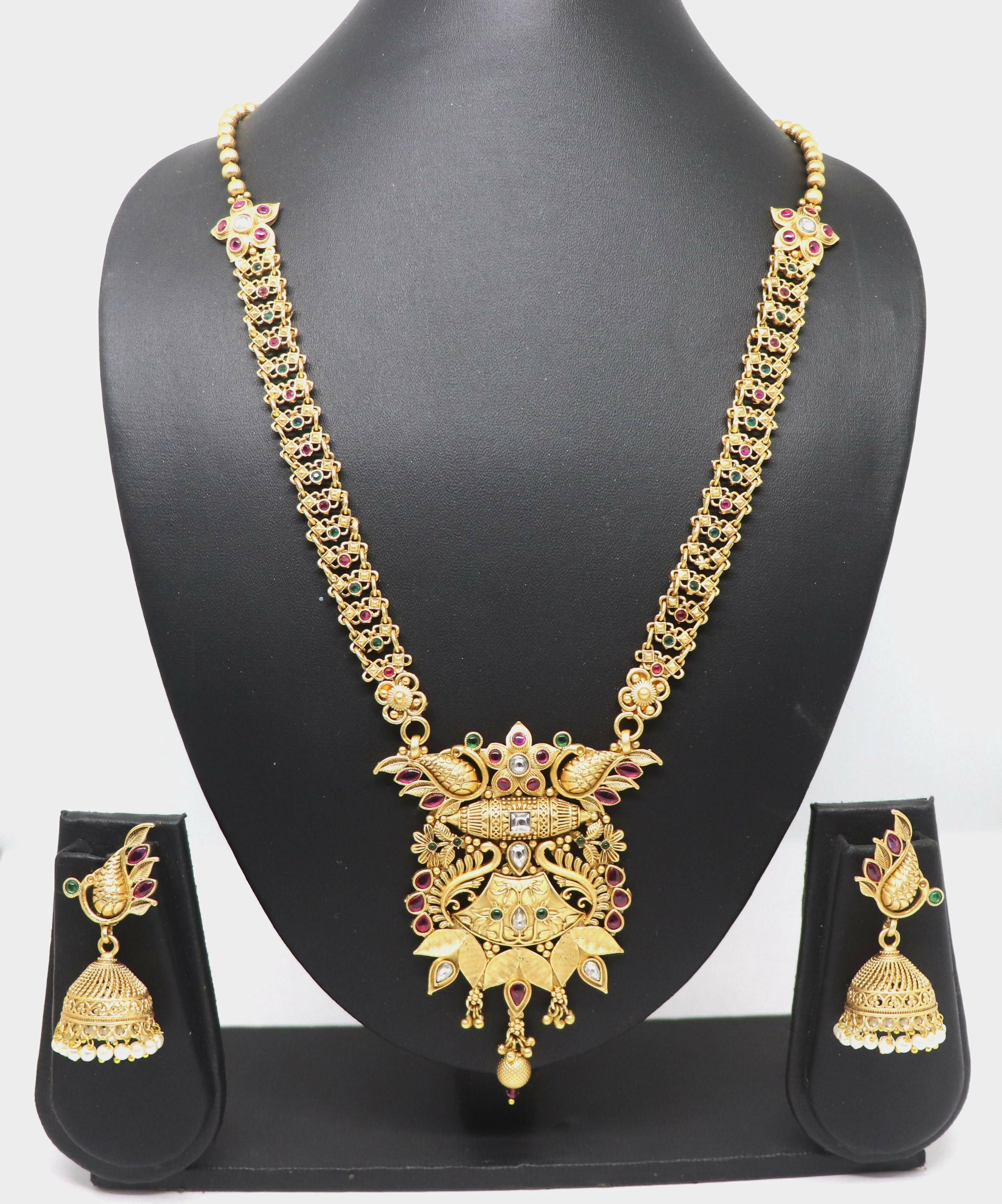 Elegant pure brass necklace set with Rajwadi polish and stone embellishments on a display stand.