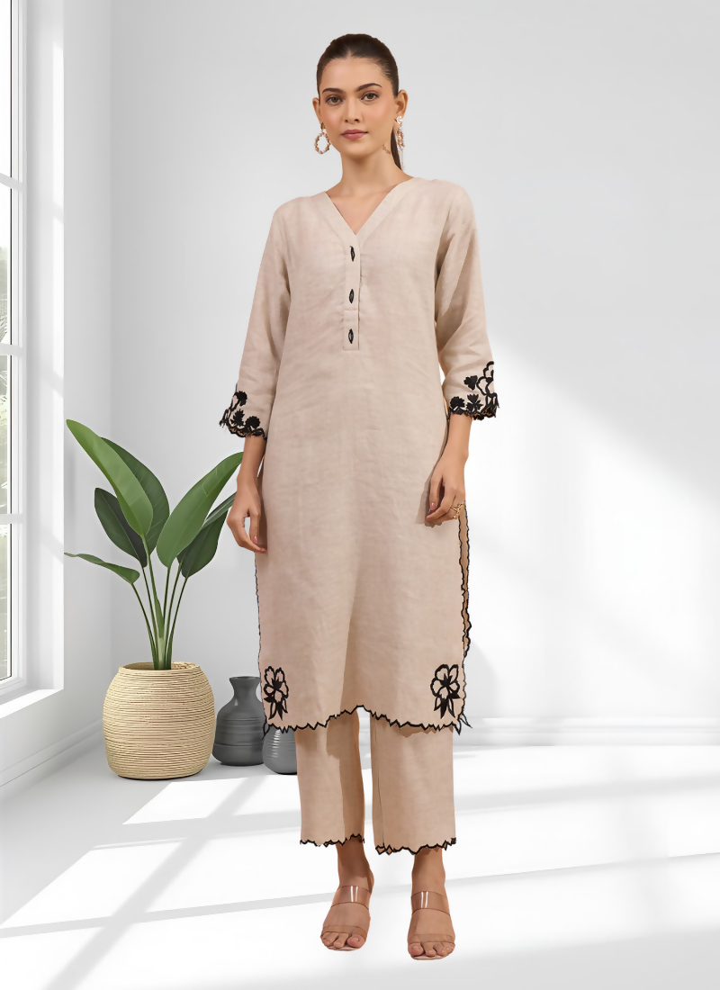 Woman wearing a beige linen long kurta with matching pants featuring intricate embroidery detail.