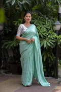 Green poly georgette saree with leaf woven pattern and mirror work blouse
