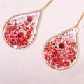 Hồng Phúc red glitter gold threader earrings hanging gracefully.