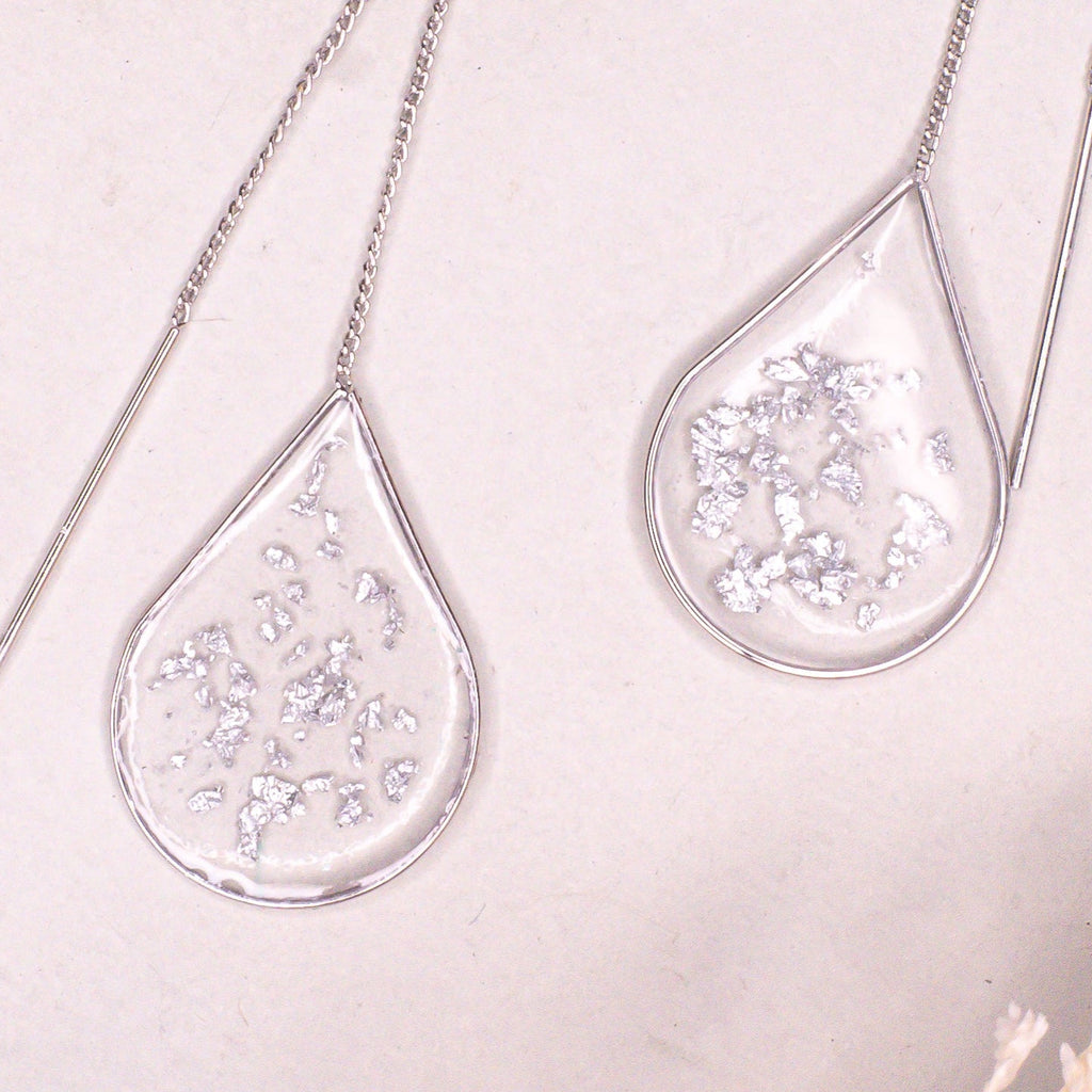 Minimalist Anh Thư silver ear threaders on a clean background.