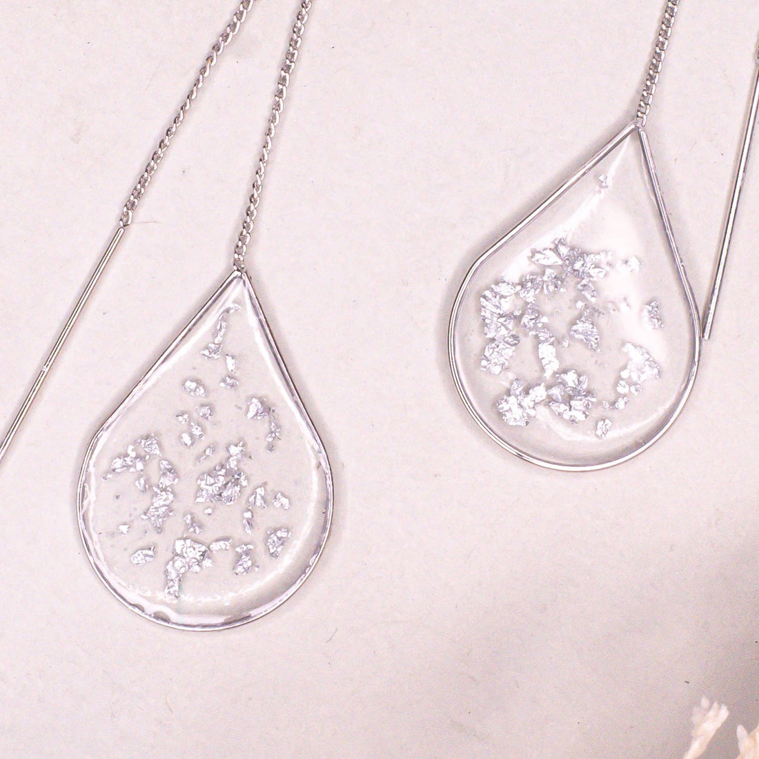 Minimalist Anh Thư silver ear threaders on a clean background.