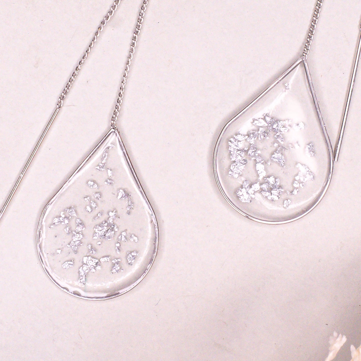 Minimalist Anh Thư silver ear threaders on a clean background.