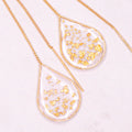 Close-up of Anh Thư gold ear threaders showing polished finish.
