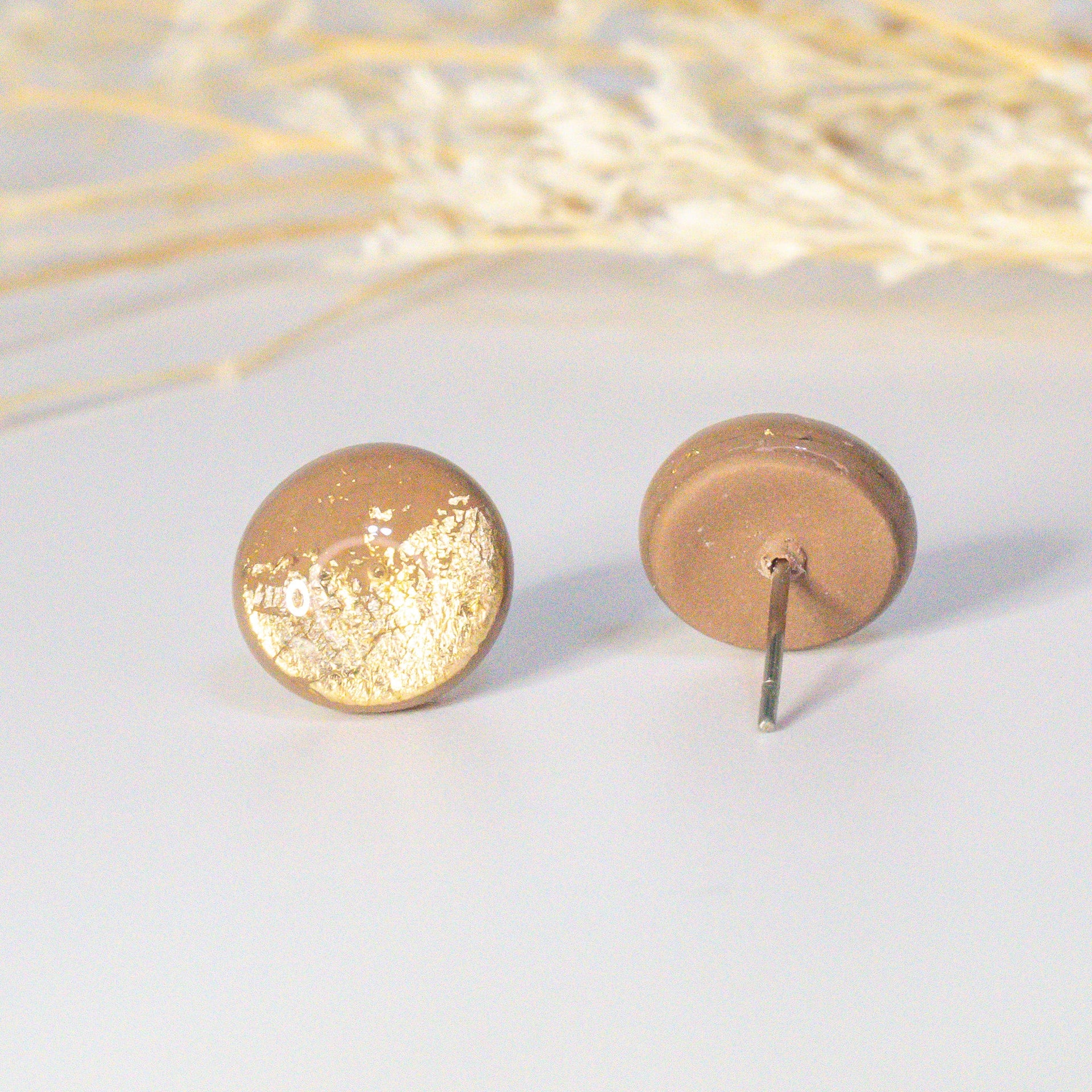 Thảo Mộc minimalist stud earrings in beige with gold flakes.