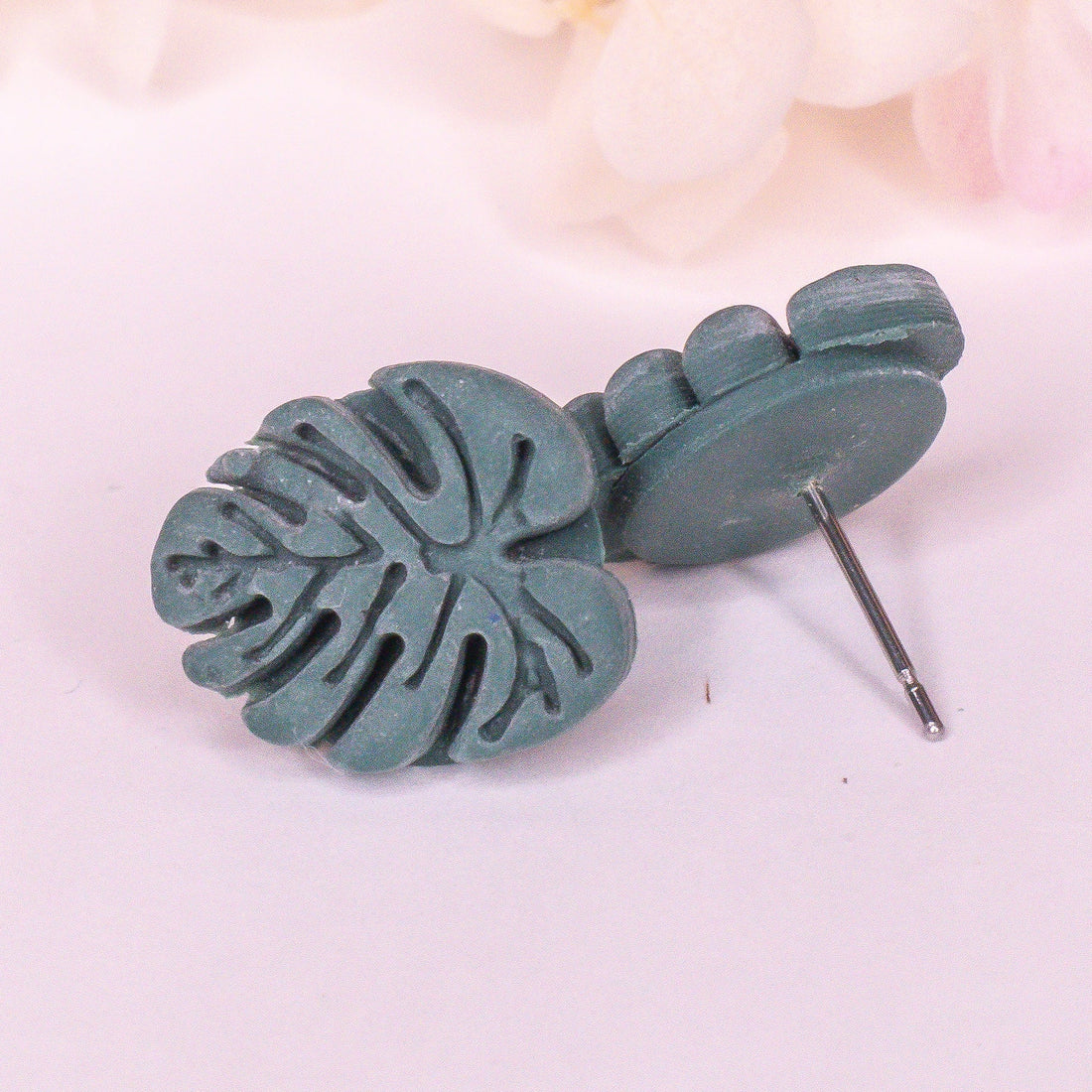 Mini Monstera studs in earthy green with a matte finish.